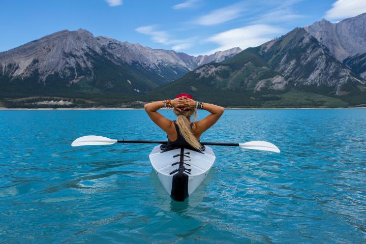 woman on a kayak in a clear blue lake